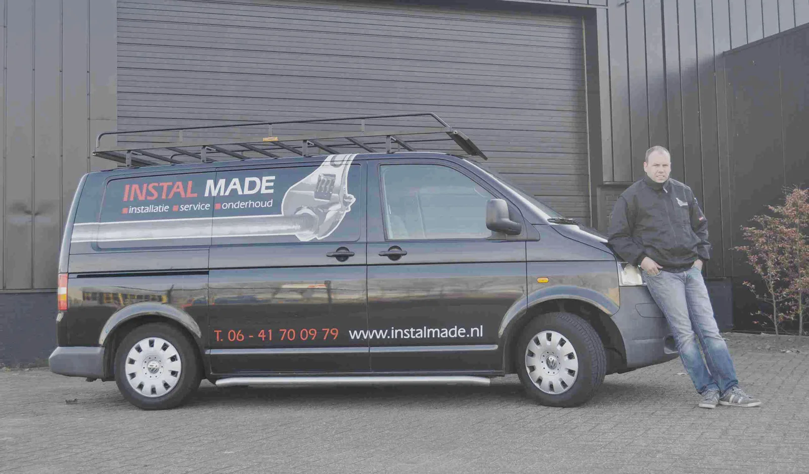 De bedrijfsbus van Instal Made met de installateur ernaast